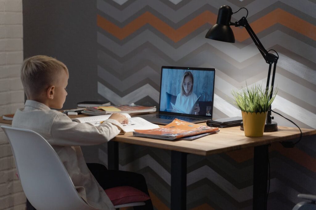 pexels-photo-5303591 A young boy focused on a virtual class at his home desk, embracing modern education technology.